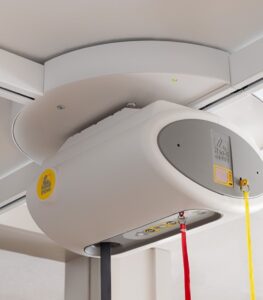 SureHands ceiling lift turntable mounted on an overhead track, allowing smooth 4-way track transitions for accessing multiple transfer locations in a home or healthcare setting.