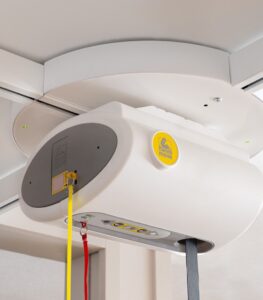 SureHands ceiling lift turntable mounted on an overhead track, allowing smooth 4-way track transitions for accessing multiple transfer locations in a home or healthcare setting.