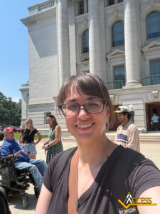 Cassandra from Access takes a photo in front of the State Capitol,